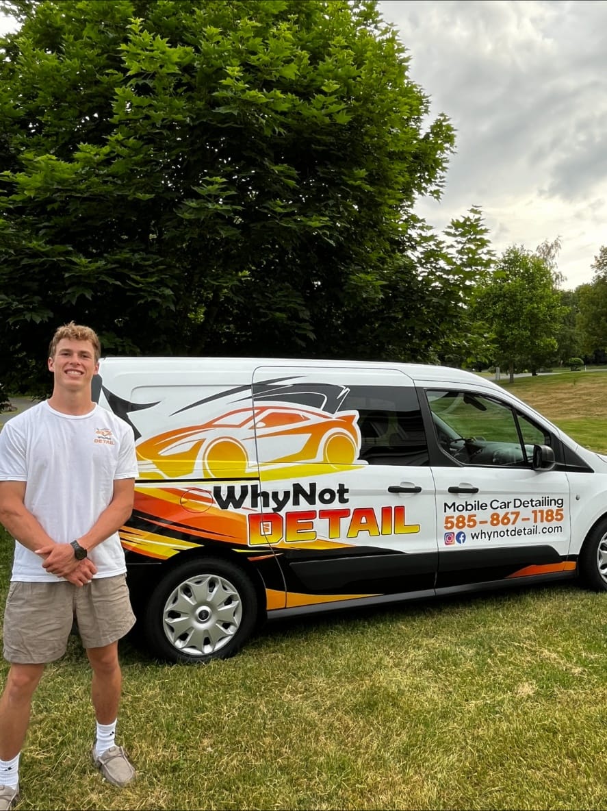Keaton, founder of WhyNot Detail, standing next to his work truck filled with detailing equipment