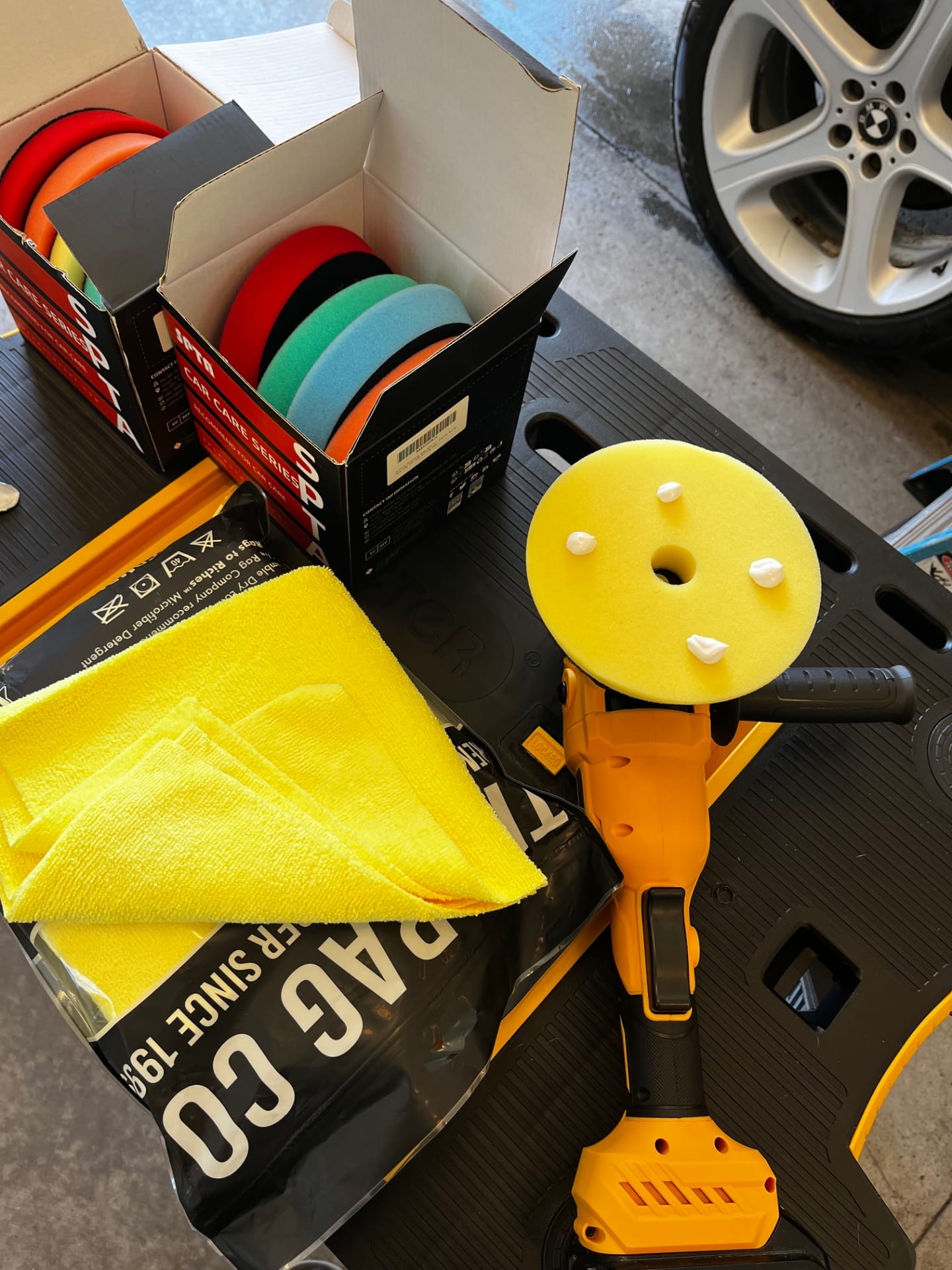Paint correction supplies including polishing pads, microfiber towels, and polisher